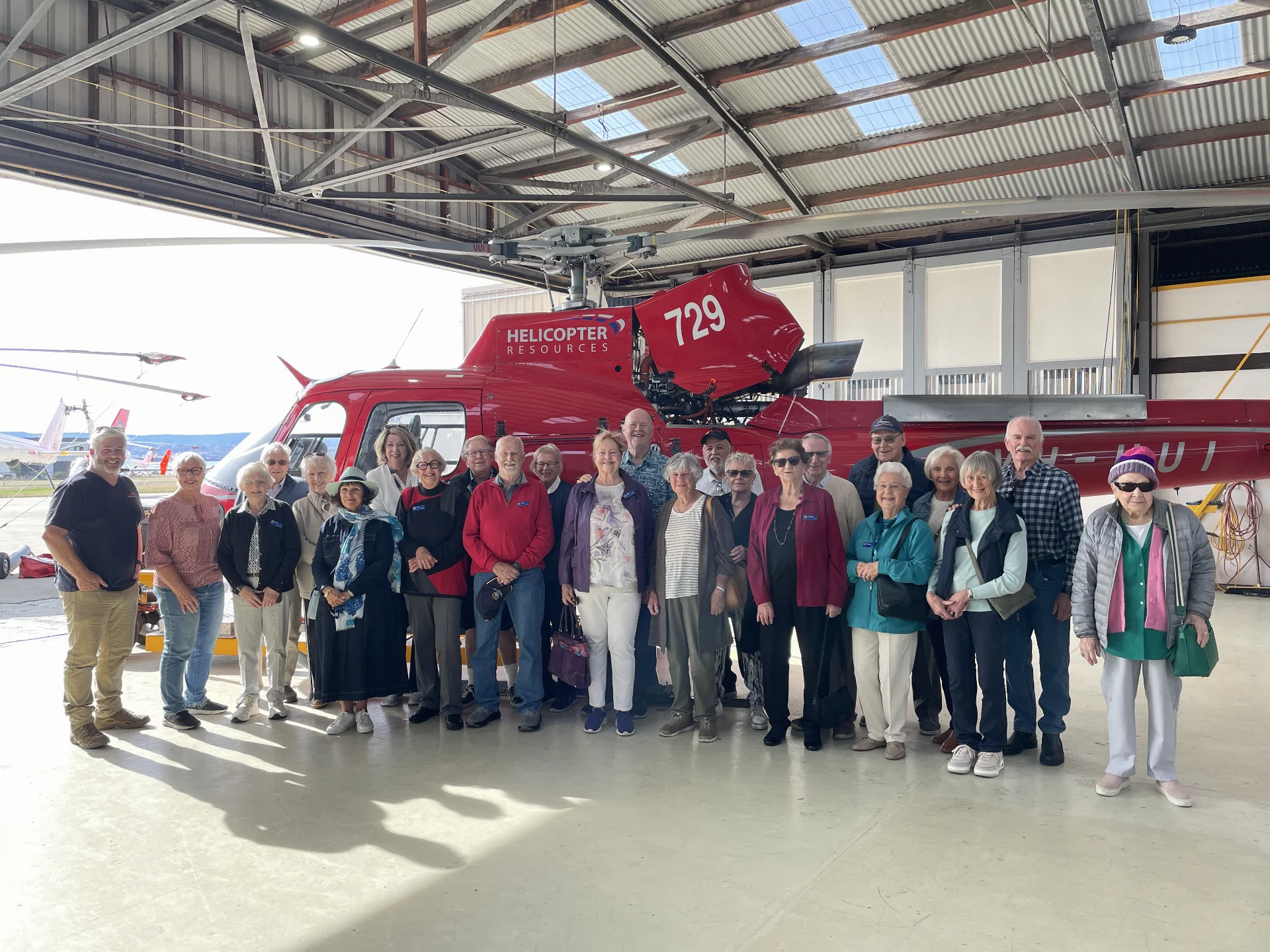 Photo of members in a helicopter hangar.